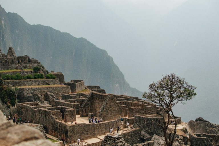 Explore the stunning ancient ruins of Machu Picchu in the misty Andes Mountains.