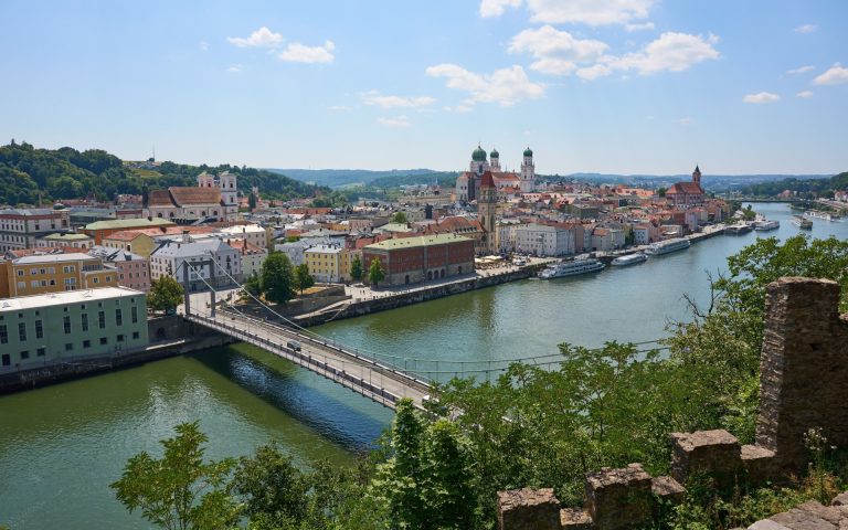 Scenic aerial view of Passau, Germany featuring the townscape, rivers, and iconic landmarks on a sunny day.