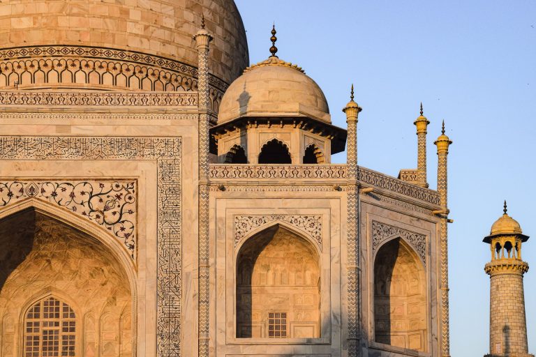 Intricate architectural details of the iconic Taj Mahal at sunset highlighting its elaborate design.