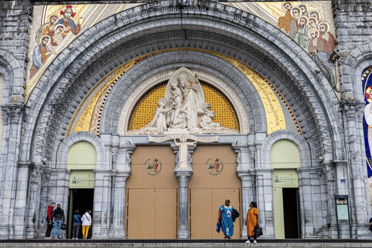 The grand entrance of Lourdes Basilica, featuring stunning religious art and architecture.