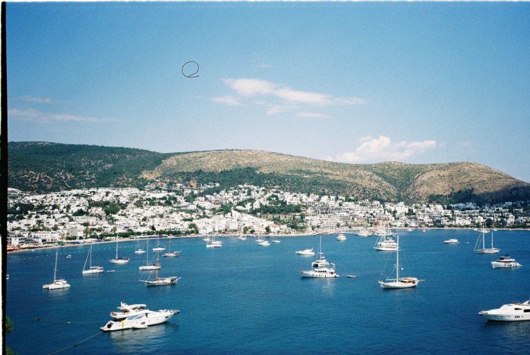 Sunny day view of Bodrum's coastline with yachts in Turkey's Aegean region.