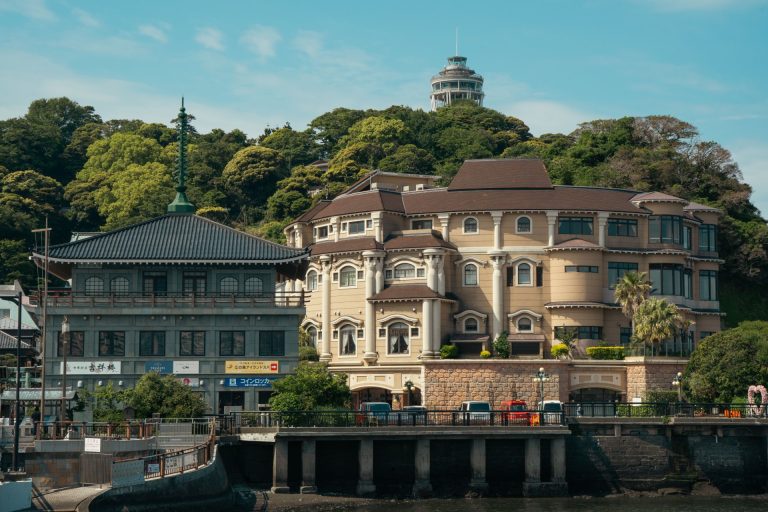 Elegant architecture with lush greenery in Fujisawa, Japan featuring Enoshima Observatory in the backdrop.