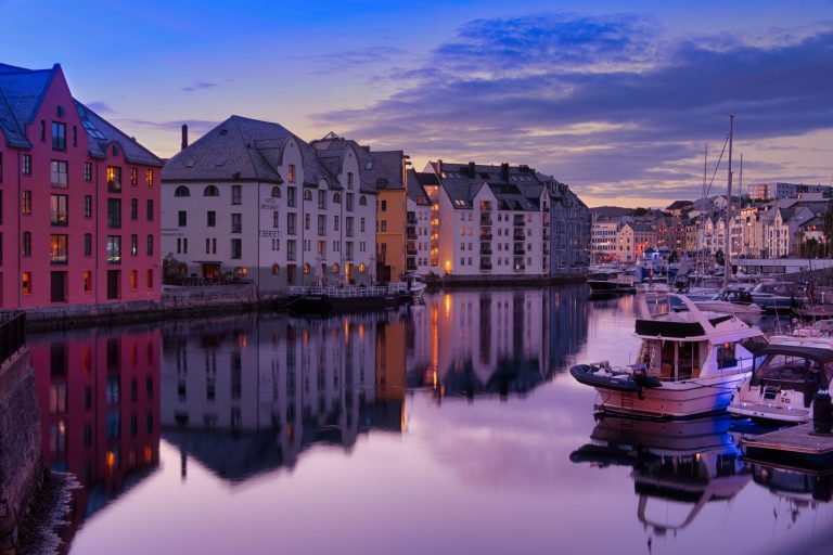Charming Ålesund waterfront with colorful buildings and boats during dusk. Perfect urban cityscape view.