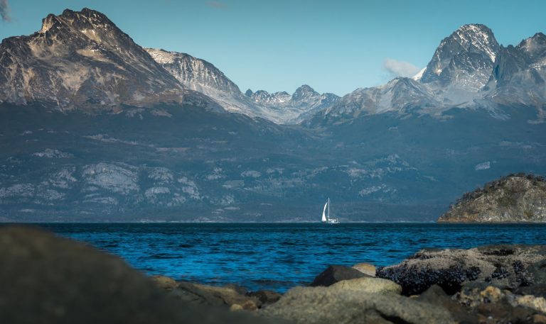 Serene sailboat on lake with Andes backdrop in Ushuaia, Argentina.