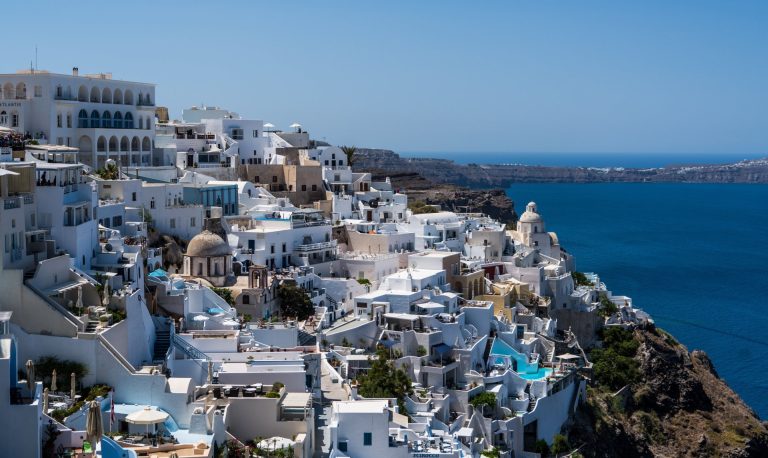 Discover the beauty of Santorini's white-washed buildings against the blue Aegean Sea.