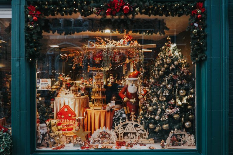 A beautifully decorated Christmas shop window featuring Santa and festive ornaments, evoking holiday spirit.