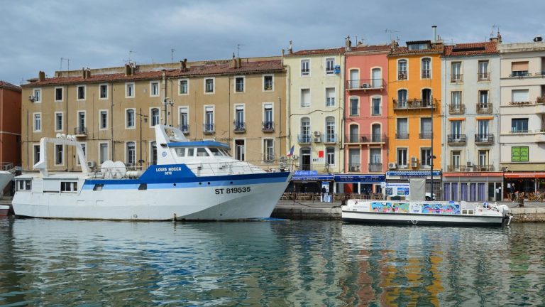 Scenic view of boats docked by vibrant buildings in Sète, Occitanie, France.